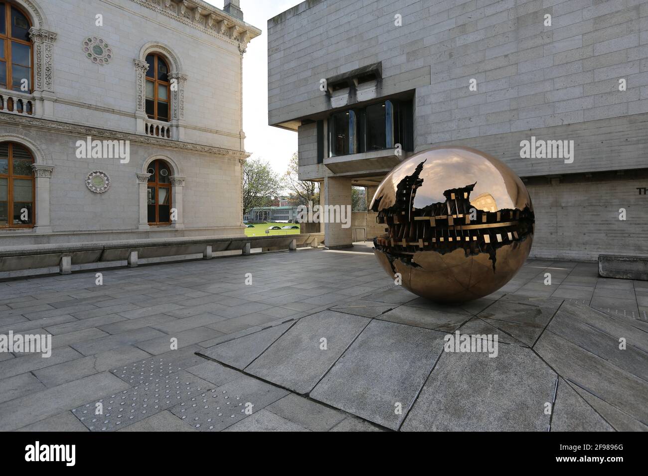DUBLIN, IRLANDE - 24 mars 2021: Berkeley Library Building avec en entrée la sculpture de l'artiste Pomodoro, à l'intérieur de la zone Trinity Collage. Banque D'Images