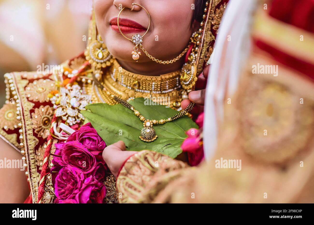Jeune mariée indienne portant une tenue traditionnelle ethnique et lourde bijoux en or Banque D'Images