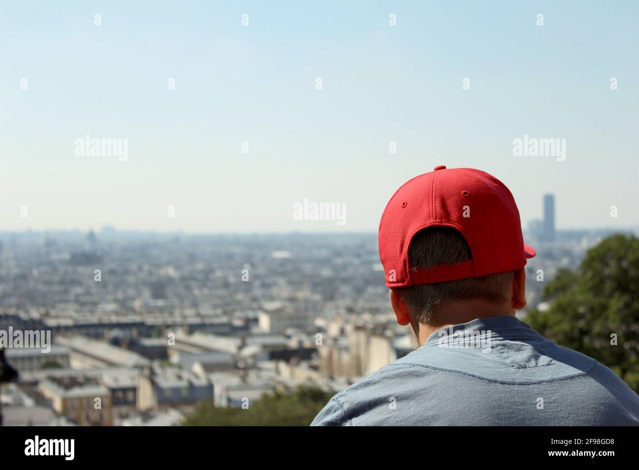 Vue arrière d'un homme portant une casquette rouge avec Paysage urbain de  Montmartre en arrière-plan Photo Stock - Alamy