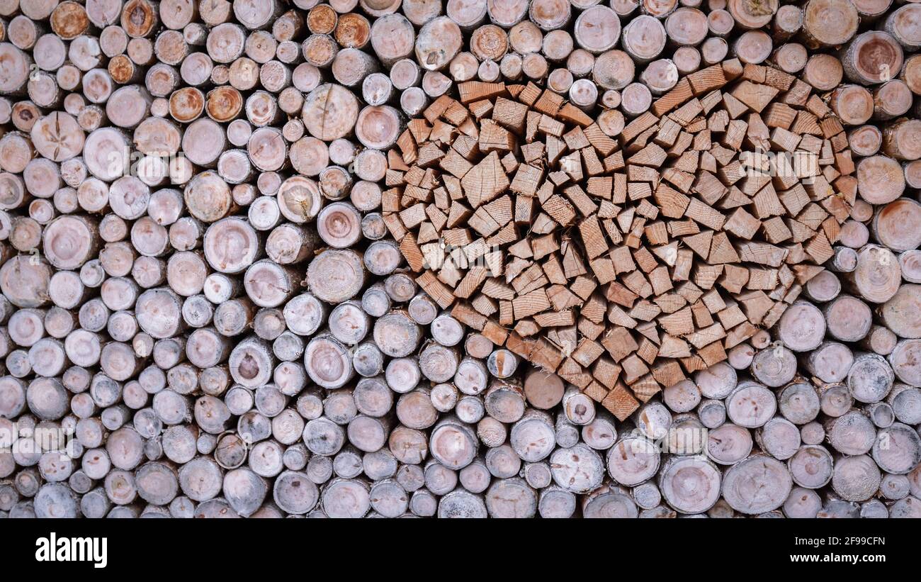 Un coeur en bois empilé dans une pile de bois de chauffage pour la cheminée ou poêle à bois. Banque D'Images