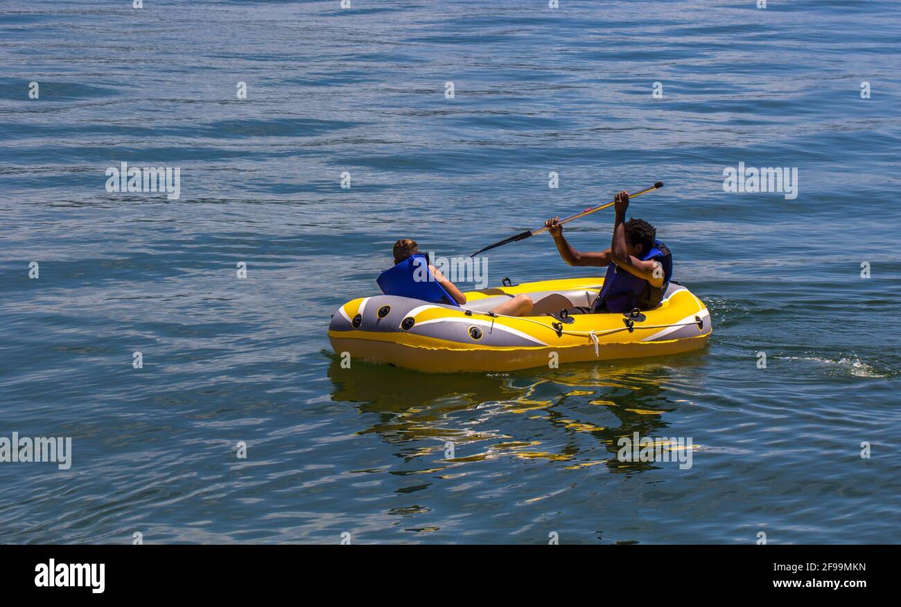 Des hommes sur un kayak gonflable jaune Banque D'Images