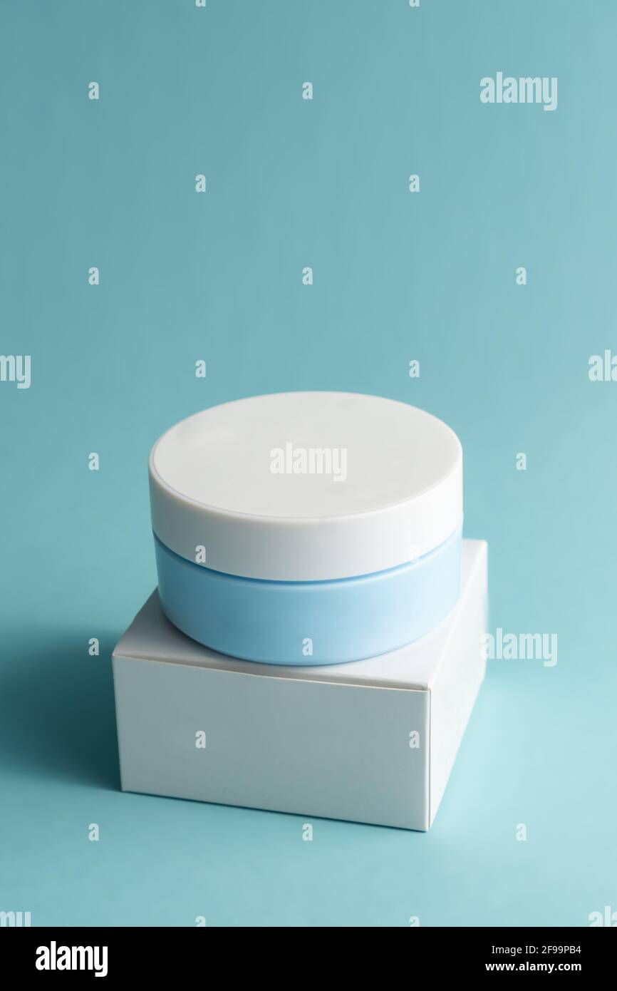 Pot crème visage avec bouchon en plastique et boîte en carton blanc,  emballage sur fond bleu. Produit de cosmétologie sans marque Mockup Photo  Stock - Alamy