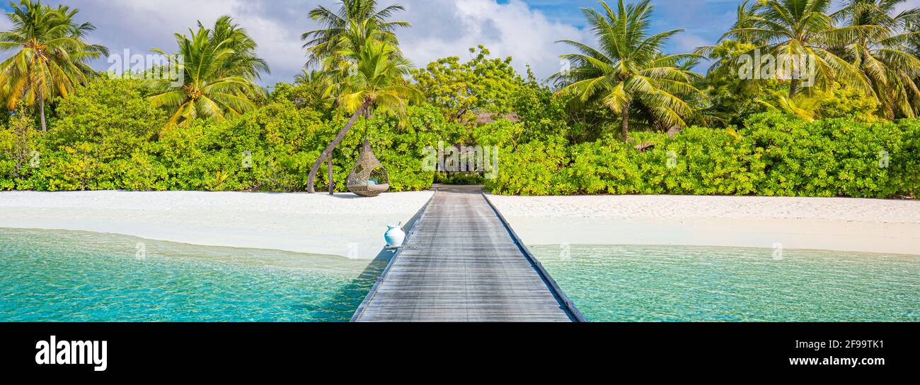 Île des Maldives, complexe de luxe, jetée en bois dans la plage paradisiaque. Magnifique ciel et nuages palmiers fond pour les vacances d'été, voyage Banque D'Images