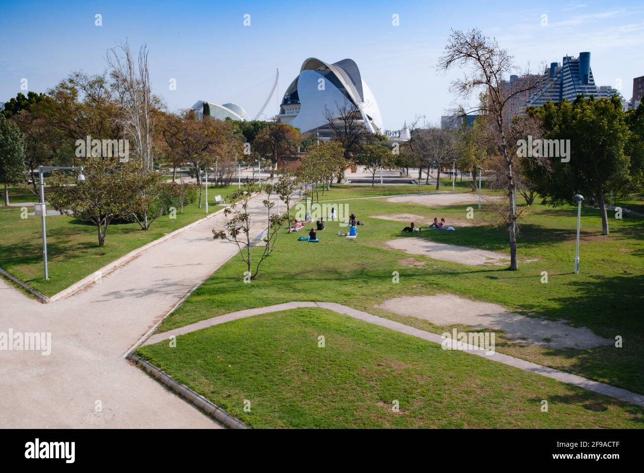 Un groupe de femmes s'exerçant dans les jardins de Turia à Valence, Espagne. Vue sur les personnes appréciant le parc pendant un après-midi de printemps. Les architectures modernes Banque D'Images