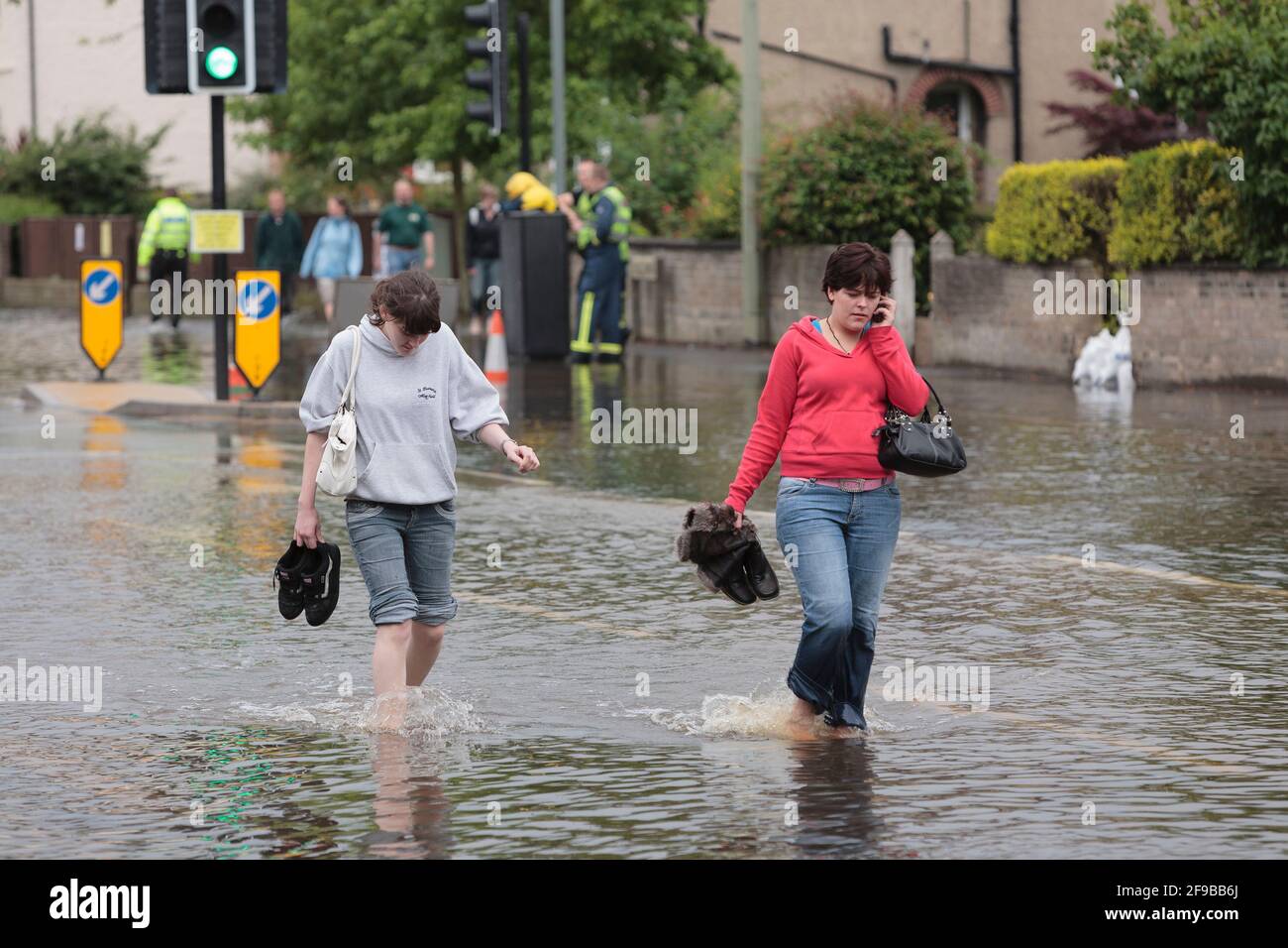Des femmes se sont emparées des eaux d'inondation, Abingdon Road, à l'ouest d'Oxford après des pluies torrentielles non saisonnières qui ont conduit à la Tamise et à ses affluents à briser leurs berges. 250 maisons dans la région d'Abingdon et de Botley Road à l'ouest d'Oxford où il a été évacué. Abingdon Road, Oxford, Royaume-Uni. 23 juillet 2007 Banque D'Images