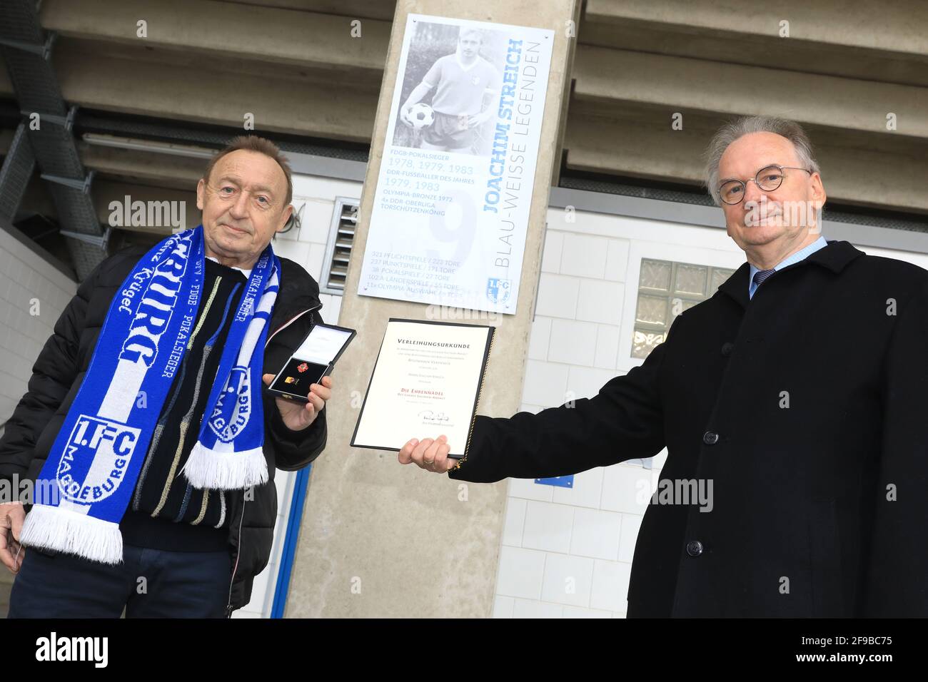 Magdebourg, Allemagne. 17 avril 2021. Le ministre, le président Reiner Haseloff (CDU, r), honore Joachim Streich, un joueur de longue date de la FCM et un disque international de la RDA, avec un certificat et une plaque « ile of Legends » devant l'arène de la MDCC. Le marqueur de but record de l'équipe nationale de la RDA et de la première ligue de la RDA a atteint 70 le 13 avril. Credit: Peter Gercke/dpa-Zentralbild/dpa/Alay Live News Banque D'Images