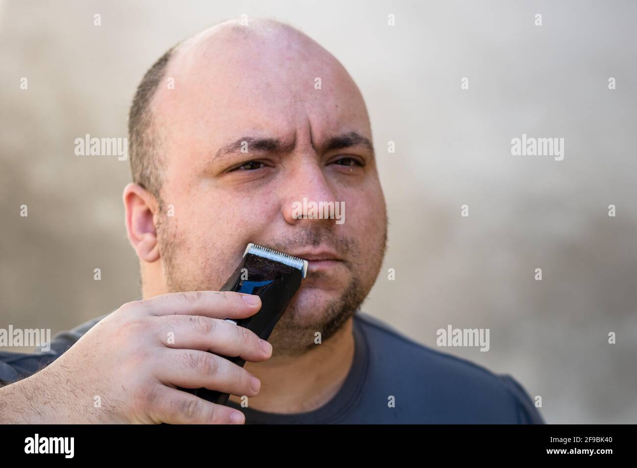 Un homme se rasant ou tailler sa barbe à l'aide d'une tondeuse à cheveux ou  rasoir électrique Photo Stock - Alamy
