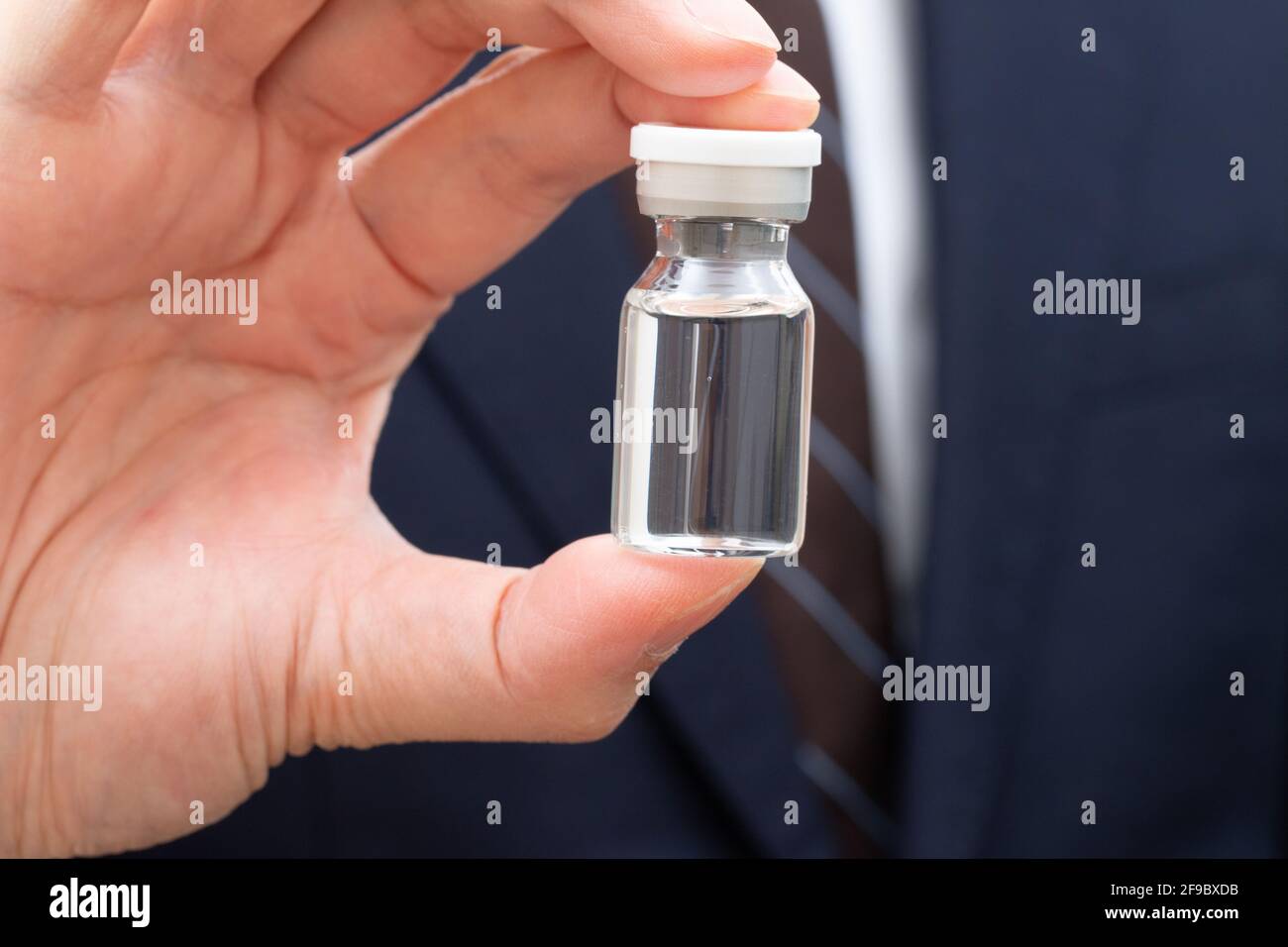 Flacon contenant le vaccin en main Banque D'Images