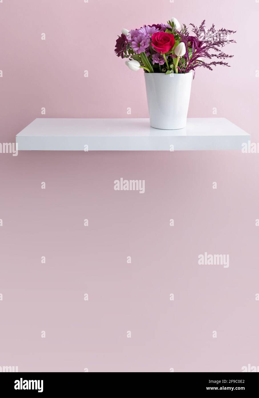 Bouquet de fleurs dans un vase sur une étagère flottante minimaliste design intérieur Banque D'Images