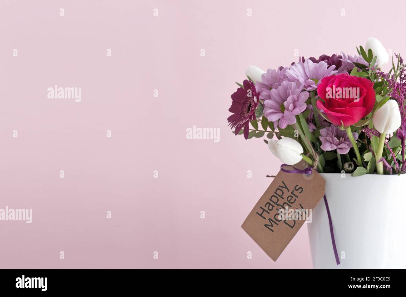 Bouquet de fleurs cadeau dans un vase blanc et étiquette vide Banque D'Images