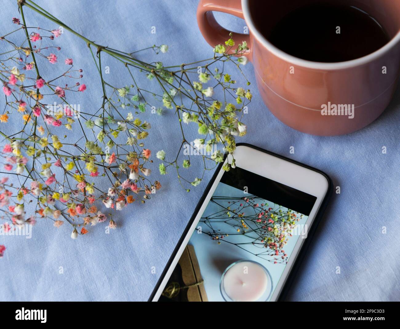 Tasse de thé, gadget, fleurs séchées sur fond bleu Banque D'Images