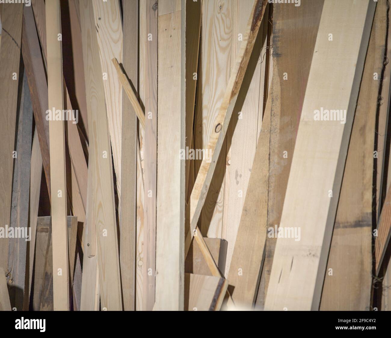 Différentes tailles et formes de planches en bois penchées sur le mur Banque D'Images