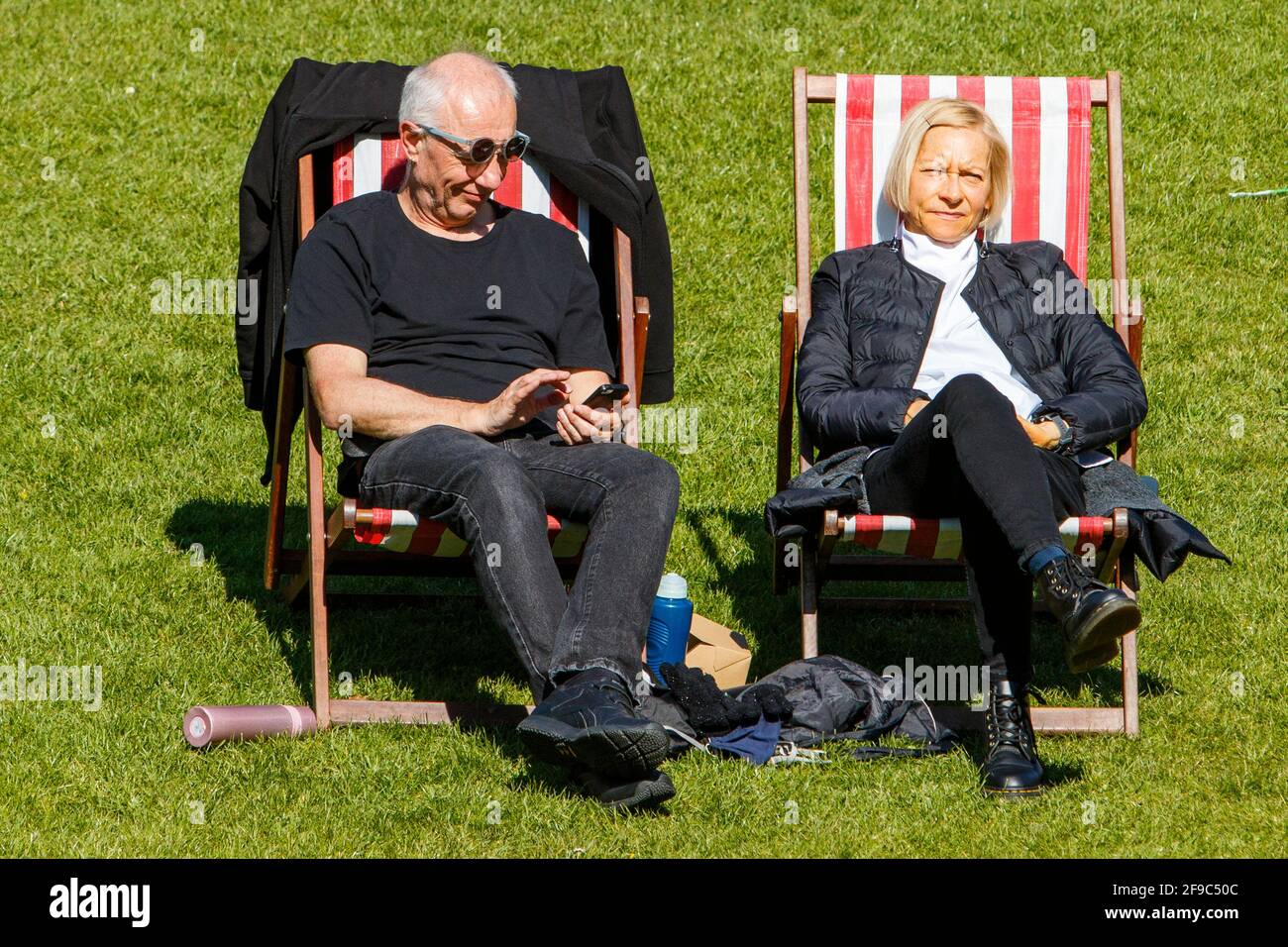 Bath, Somerset, Royaume-Uni. 17 avril 2021. Le premier samedi après la levée des restrictions de confinement à domicile de Covid en Angleterre, un couple est photographié en profitant du soleil dans Parade Gardens. Credit: Lynchpics/Alamy Live News Banque D'Images