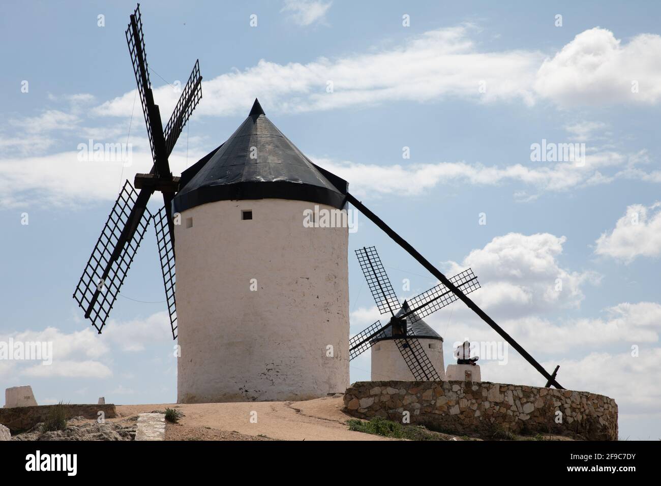 Consuegra. 17 avril 2021. Une femme est assise devant les moulins à vent de Consuegra, Espagne, sur Apirl 17, 2021. Le moulin à vent est l'un des paysages représentatifs de la région Castille-la Manche en Espagne. Credit: Meng Dingbo/Xinhua/Alay Live News Banque D'Images