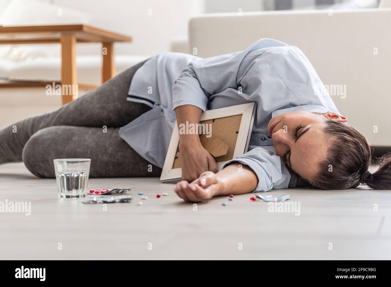 Une femme qui perd une personne proche dans sa vie surdosée par des pilules  et perdu conscience, couché sur le sol Photo Stock - Alamy