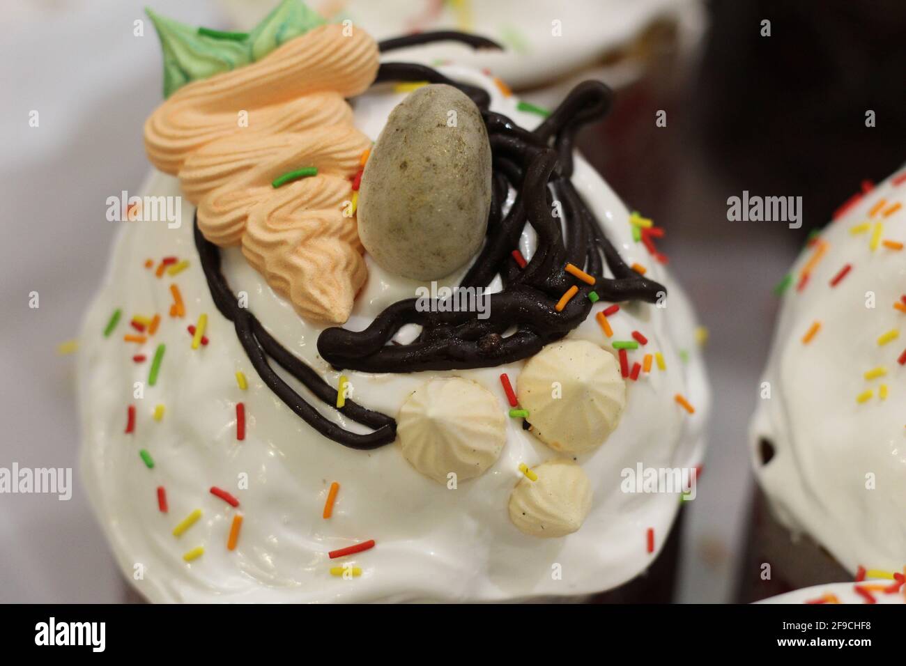 Gâteaux de Pâques fraîchement préparés sous forme de papier, décorés de fondants, de glaçage au chocolat, d'œufs en sucre et de carottes Banque D'Images