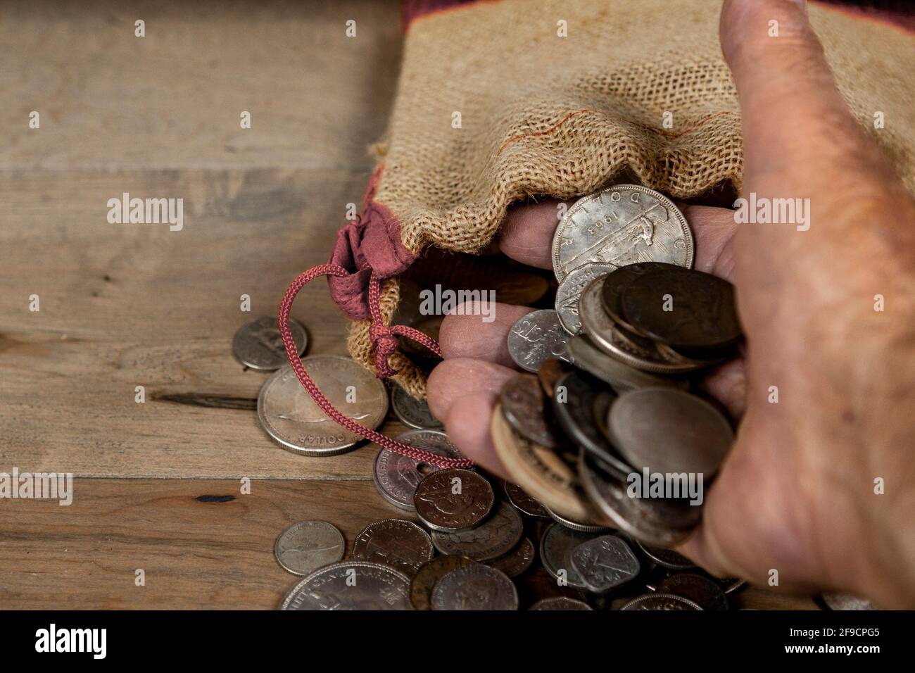 Les pièces de monnaie prises dans un petit sac sont dans la paume de votre main Banque D'Images