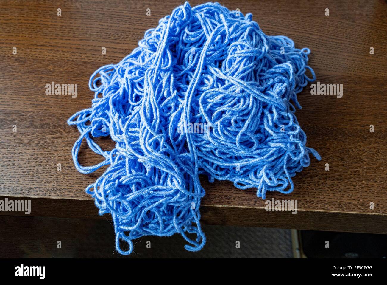 Un grand tas de fils de tricot épais enchevêtrés repose sur la table Banque D'Images