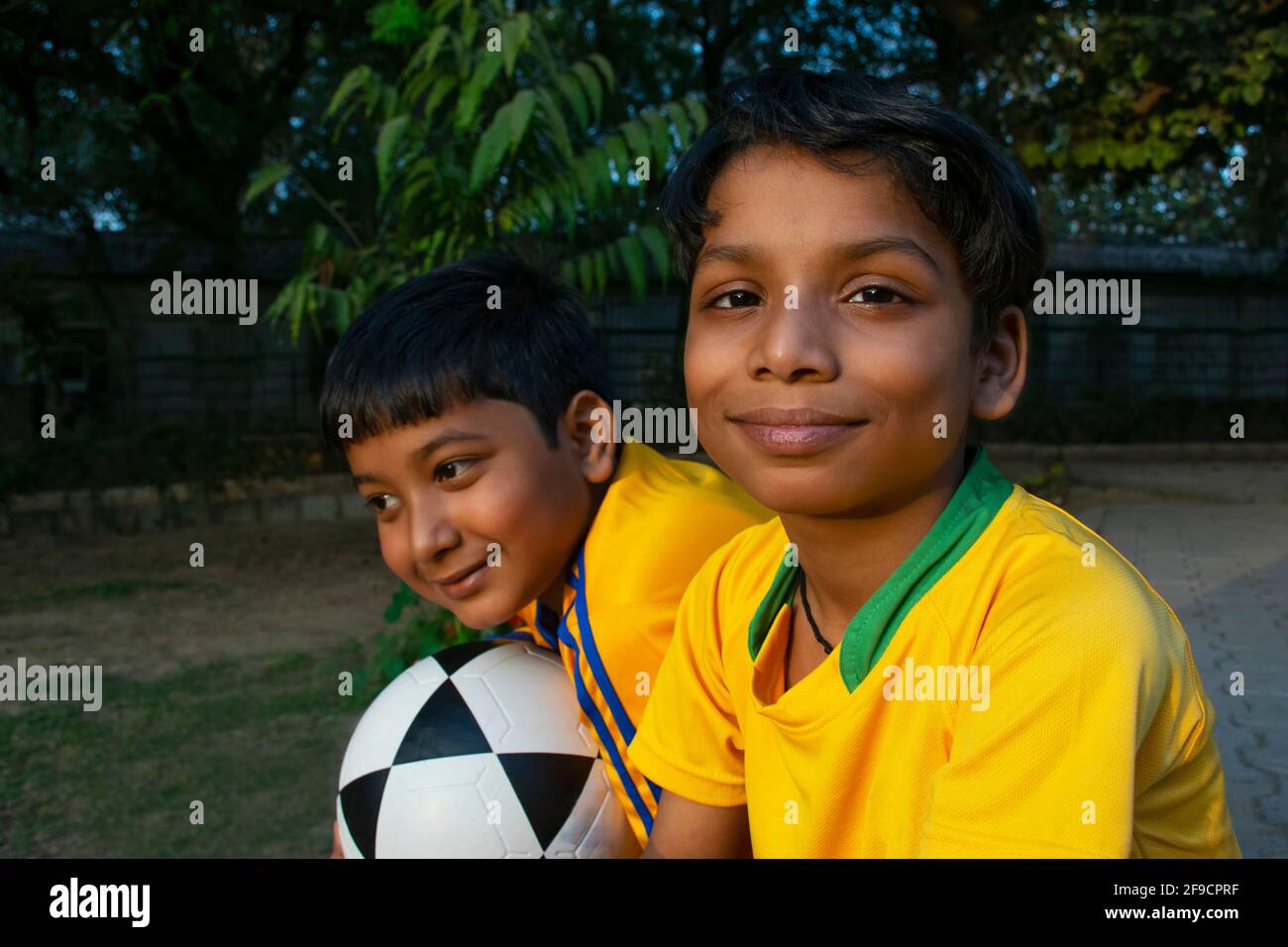 Deux indiens sont assis au sol avec un ballon de football Banque D'Images