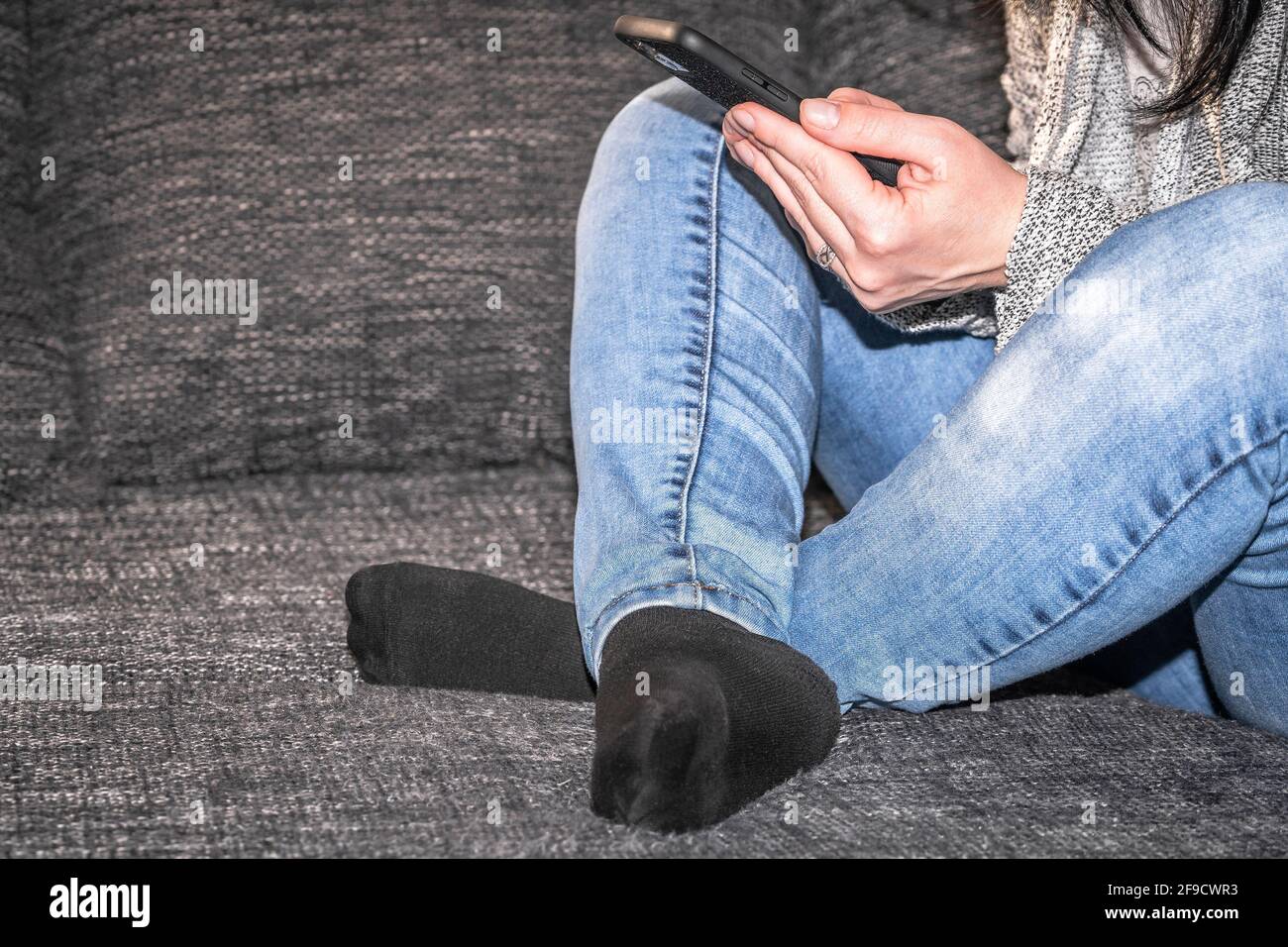 La fille est assise sur l'ensemble et tient le téléphone dans son rugissement Banque D'Images