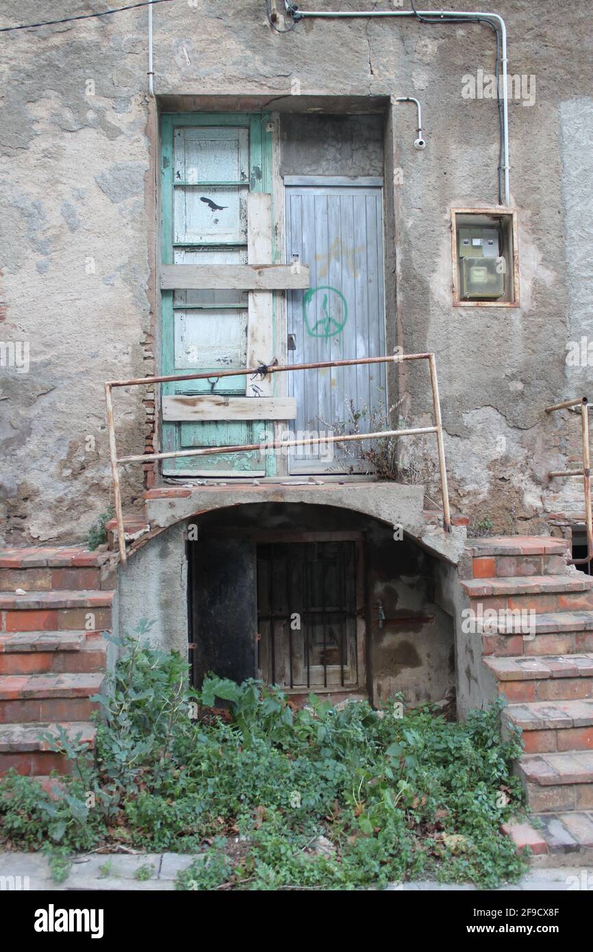 Porte fermée abandonnée, avec escalier, balcon, mains courantes, boîte à fusibles et signe de paix sur une porte en bois Banque D'Images