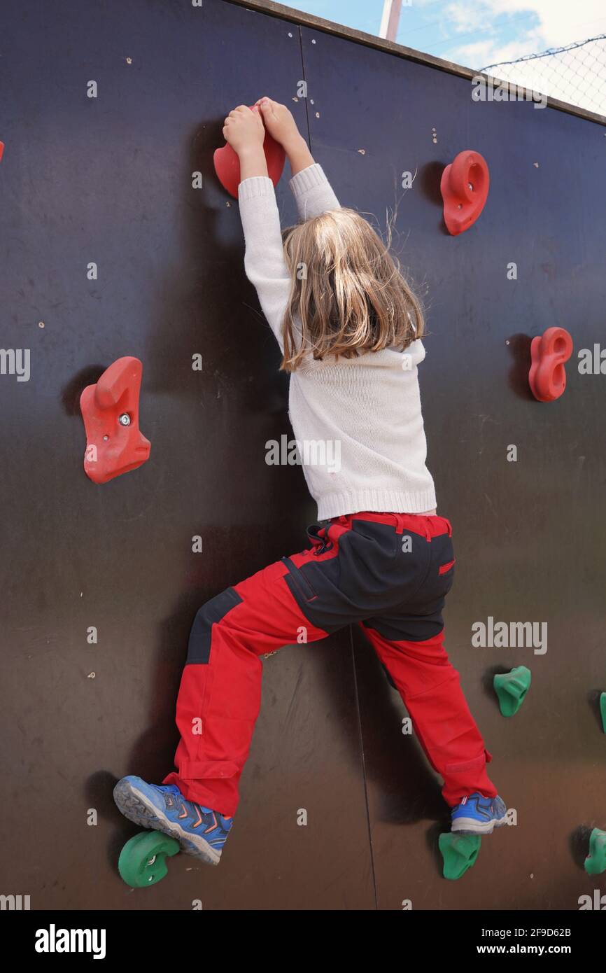 Jeune fille sur le mur d'escalade extérieur pour enfants. Banque D'Images