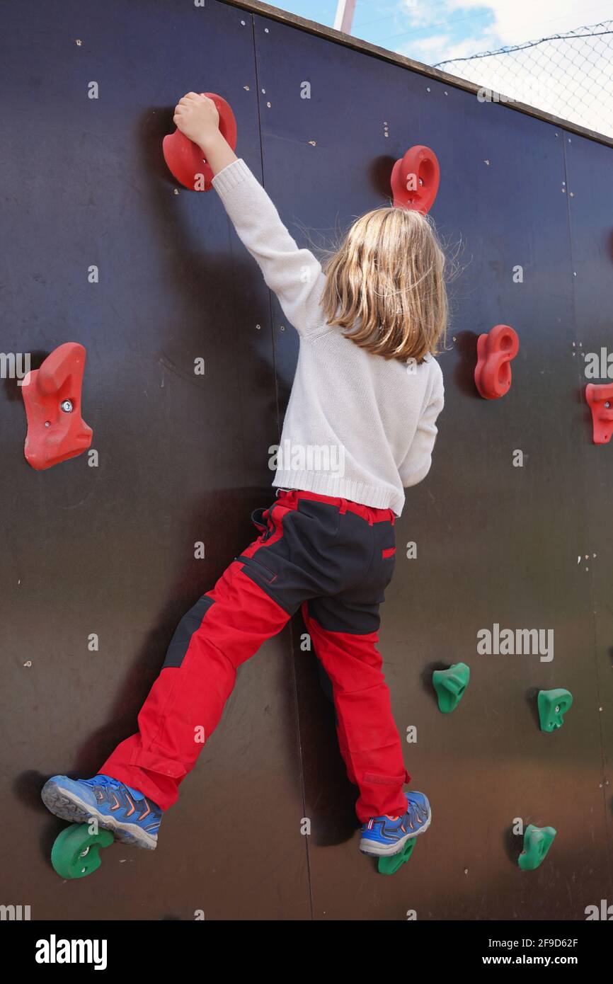 Jeune fille sur le mur d'escalade extérieur pour enfants. Banque D'Images