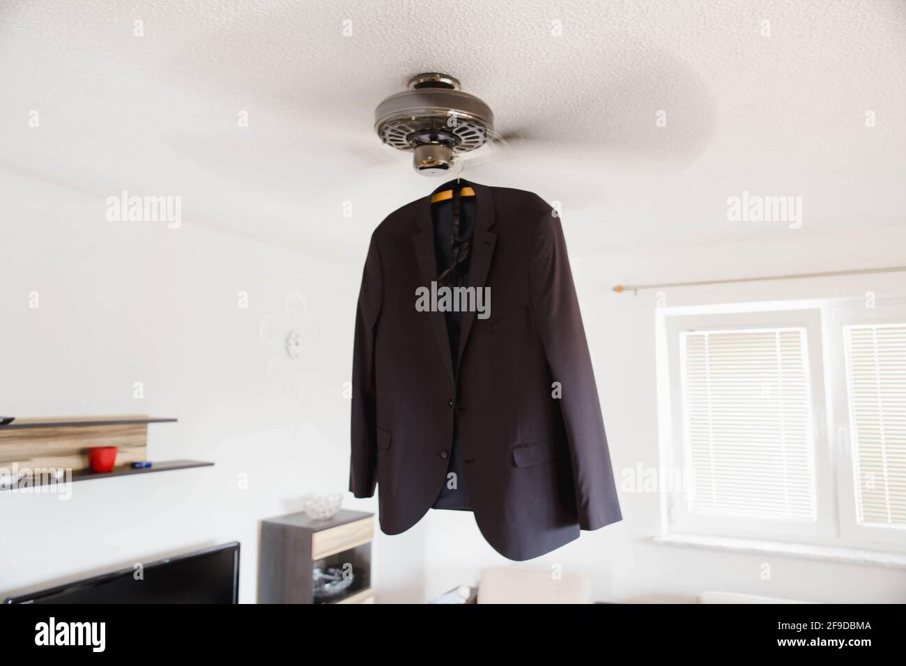 Costume habillé suspendu sous un ventilateur de plafond Banque D'Images