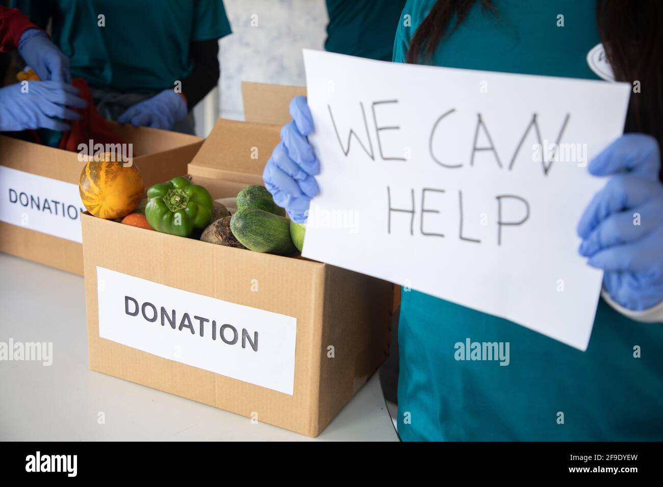 Se concentrer sur les légumes, la tenue de bénévoles nous pouvons aider à signer le tableau pendant les dons tandis que d'autres bénévoles sont occupés de travailler la formation - concept de demander Banque D'Images