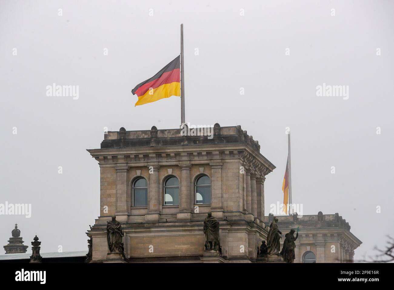Berlin, Allemagne. 18 avril 2021. Le drapeau allemand au sommet du bâtiment du Reichstag vole en Berne à l'occasion du mémorial central pour ceux qui sont morts dans la pandémie de Corona en Allemagne. Credit: Christoph Soeder/dpa/Alay Live News Banque D'Images