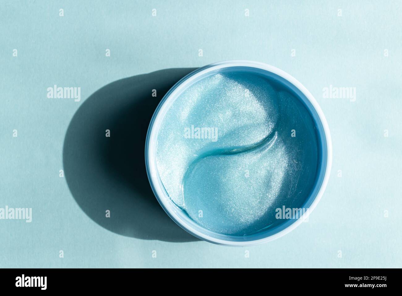 Masque de collagène bleu ou taches sur fond bleu. Soins de la peau et concept de beauté. Maquette sans marque. Banque D'Images
