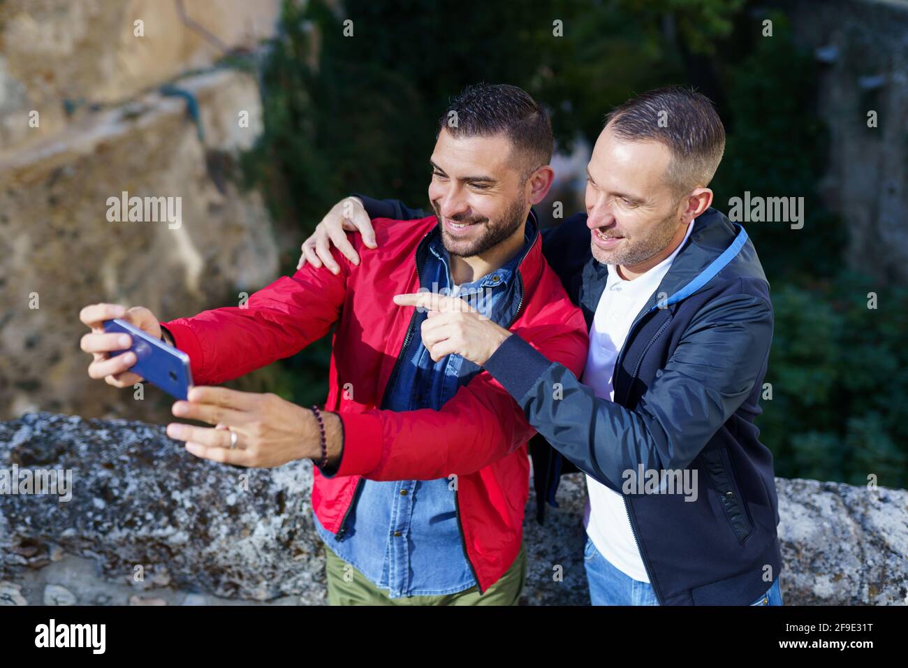 Couple gay faisant un selfie avec leur smartphone. Banque D'Images