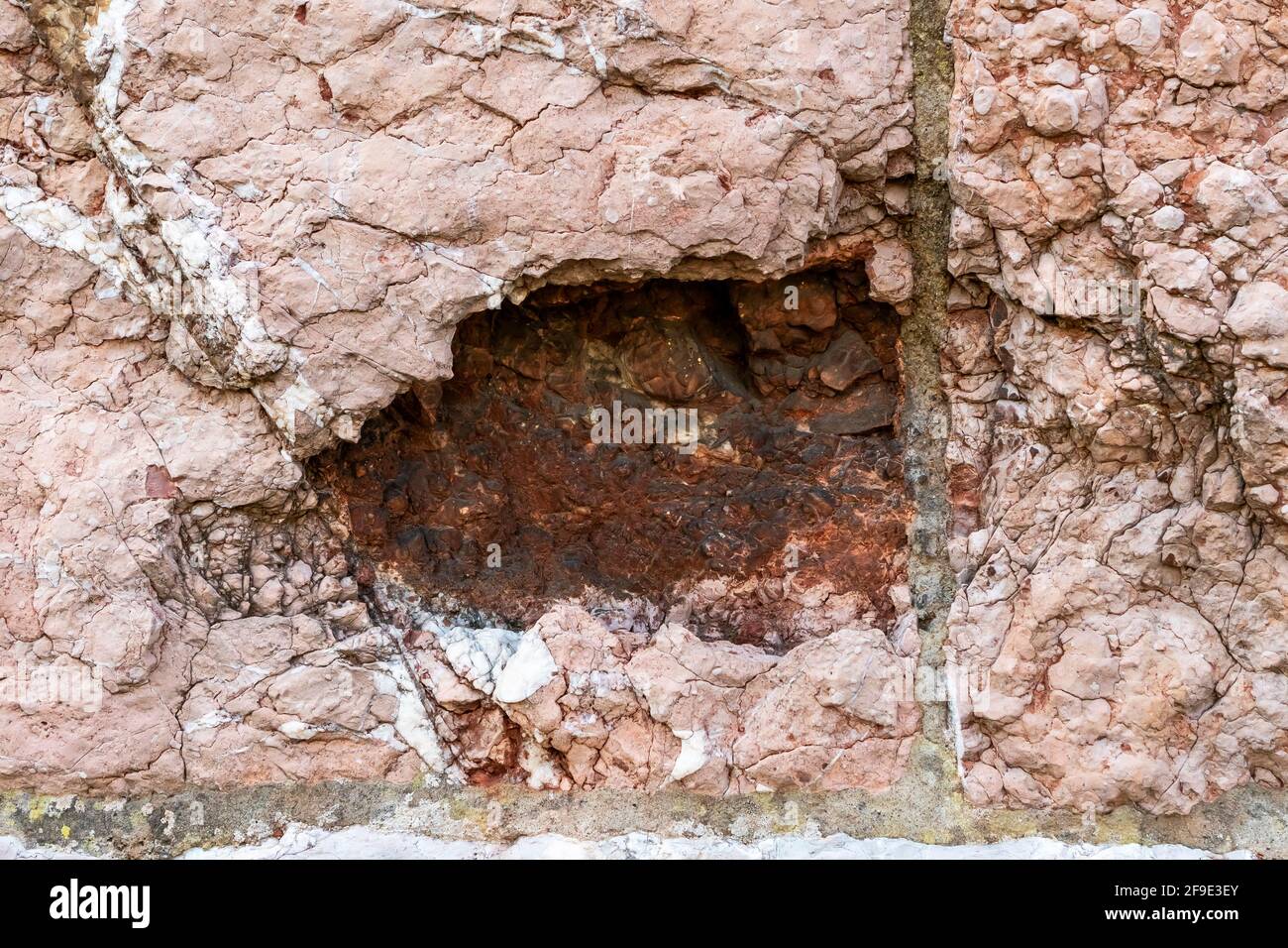 Ancien trou d'une coquille d'artillerie sur une pierre ancienne gros plan sur le mur Banque D'Images