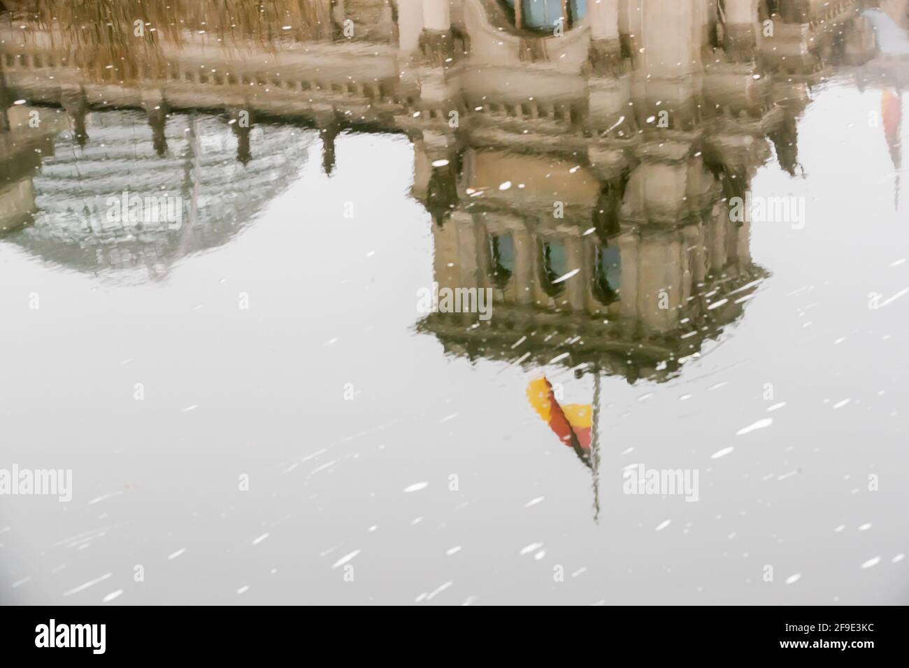 Berlin, Allemagne. 18 avril 2021. Le drapeau allemand sur le bâtiment du Reichstag vole en Berne à l'occasion du mémorial central pour ceux qui sont morts dans la pandémie de Corona en Allemagne et se reflète dans la rivière Spree. Credit: Christoph Soeder/dpa/Alay Live News Banque D'Images