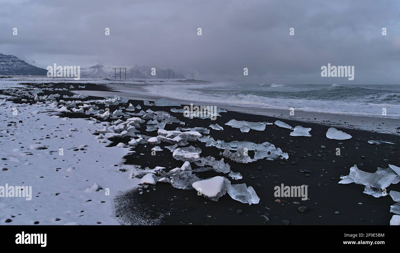 Belle vue sur la plage de diamants bruts avec du sable noir et de petits icebergs sur la côte sud de l'Islande près de Jökulsárlón et le périphérique. Banque D'Images