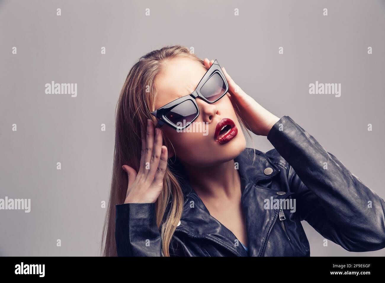 Portrait de mode de belle fille portant des lunettes de soleil. Gros plan de femme mignon sur fond blanc, isolé. Banque D'Images