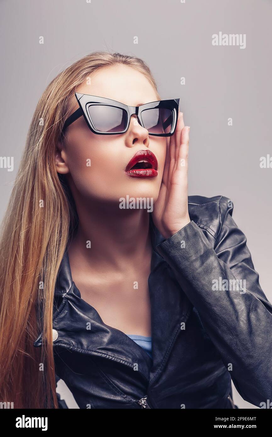 Portrait de mode de belle fille portant des lunettes de soleil. Gros plan de femme mignon sur fond blanc, isolé. Banque D'Images