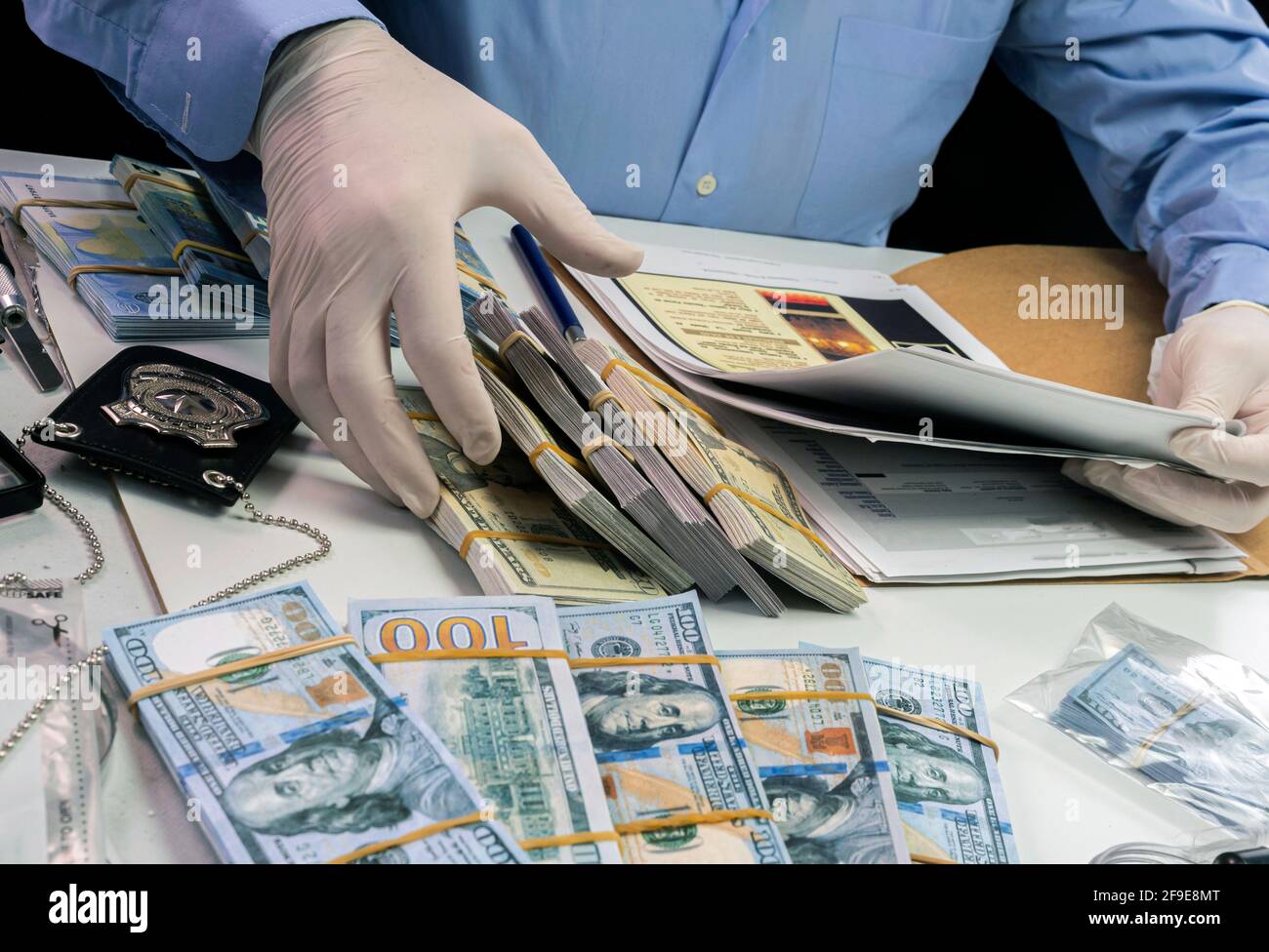 Un agent de police spécialisé note une référence de billet de banque d'un vol qualifié dans une unité d'enquête criminelle, image conceptuelle Banque D'Images