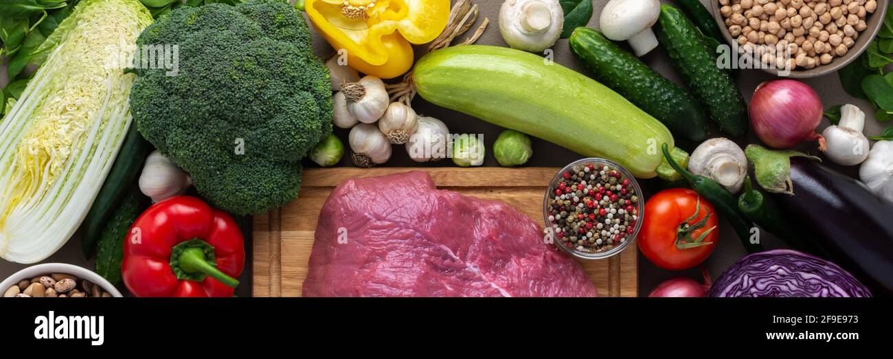 Bannière de légumes frais biologiques de ferme, concept de nourriture saine, légumes et champignons, haricots autour de la carte avec un grand morceau frais de filet de boeuf Banque D'Images