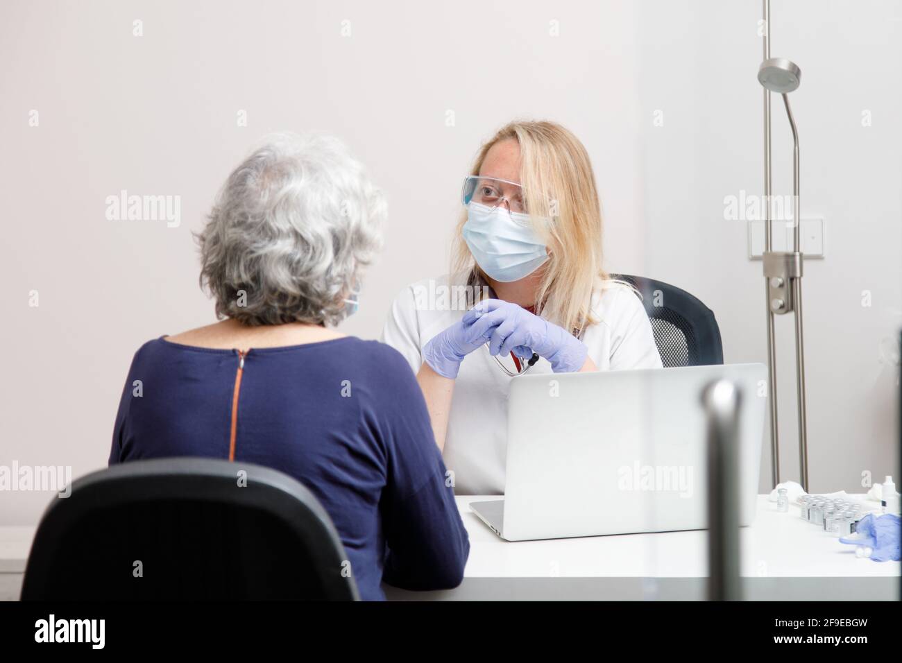 Femme médecin traitant une patiente dans son bureau médical Banque D'Images