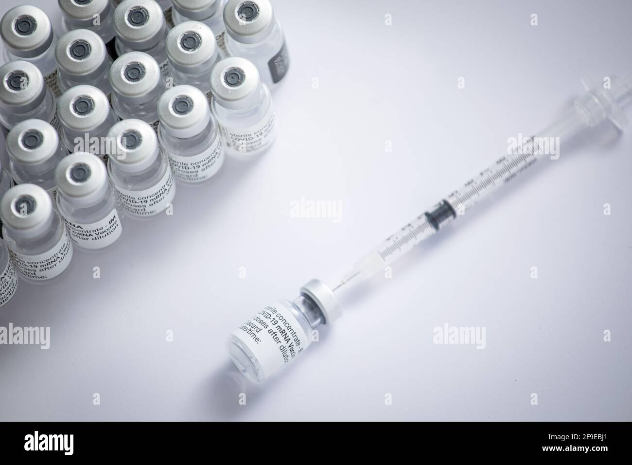 Gros plan de certains flacons avec le vaccin coronavirus avec une aiguille sur fond blanc Banque D'Images