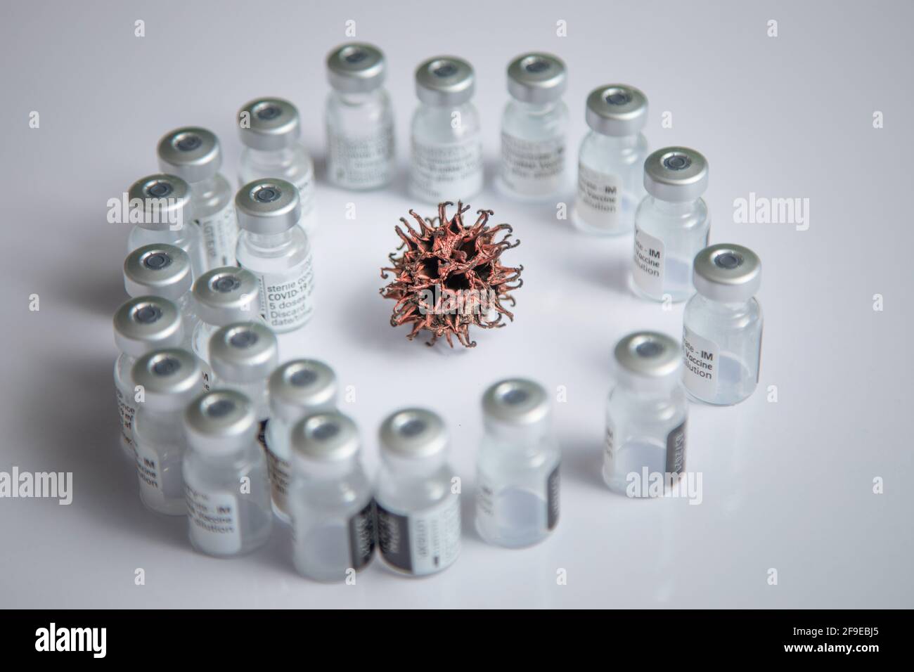 Simulation microscopique du schéma de virus COVID-19 en arrière-plan entouré par Flacons de vaccins Banque D'Images