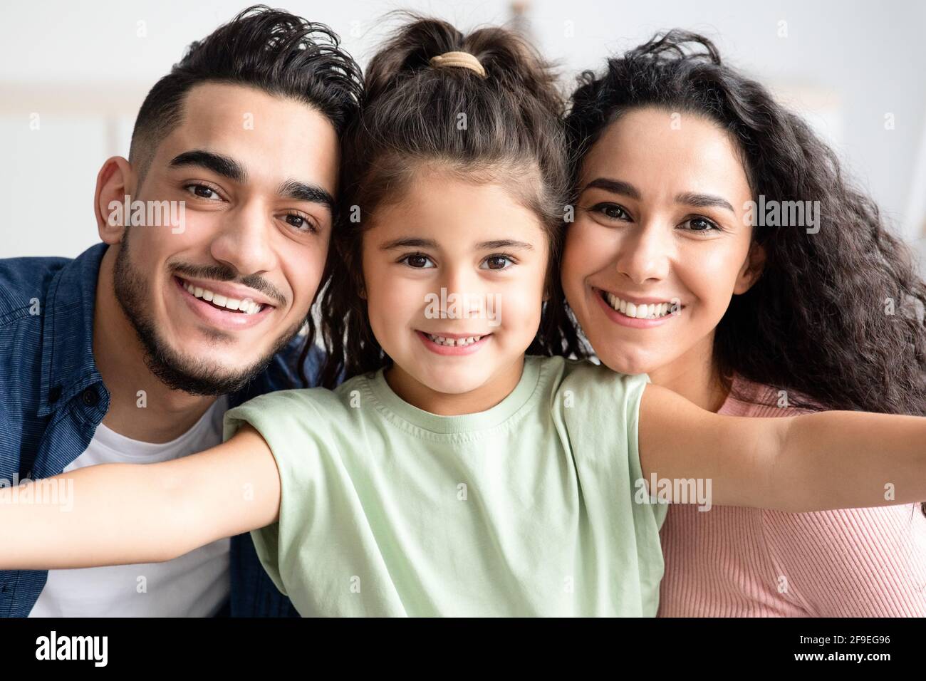 Portrait de jeune famille. Petite fille mignonne prenant Selfie avec ses parents arabes Banque D'Images