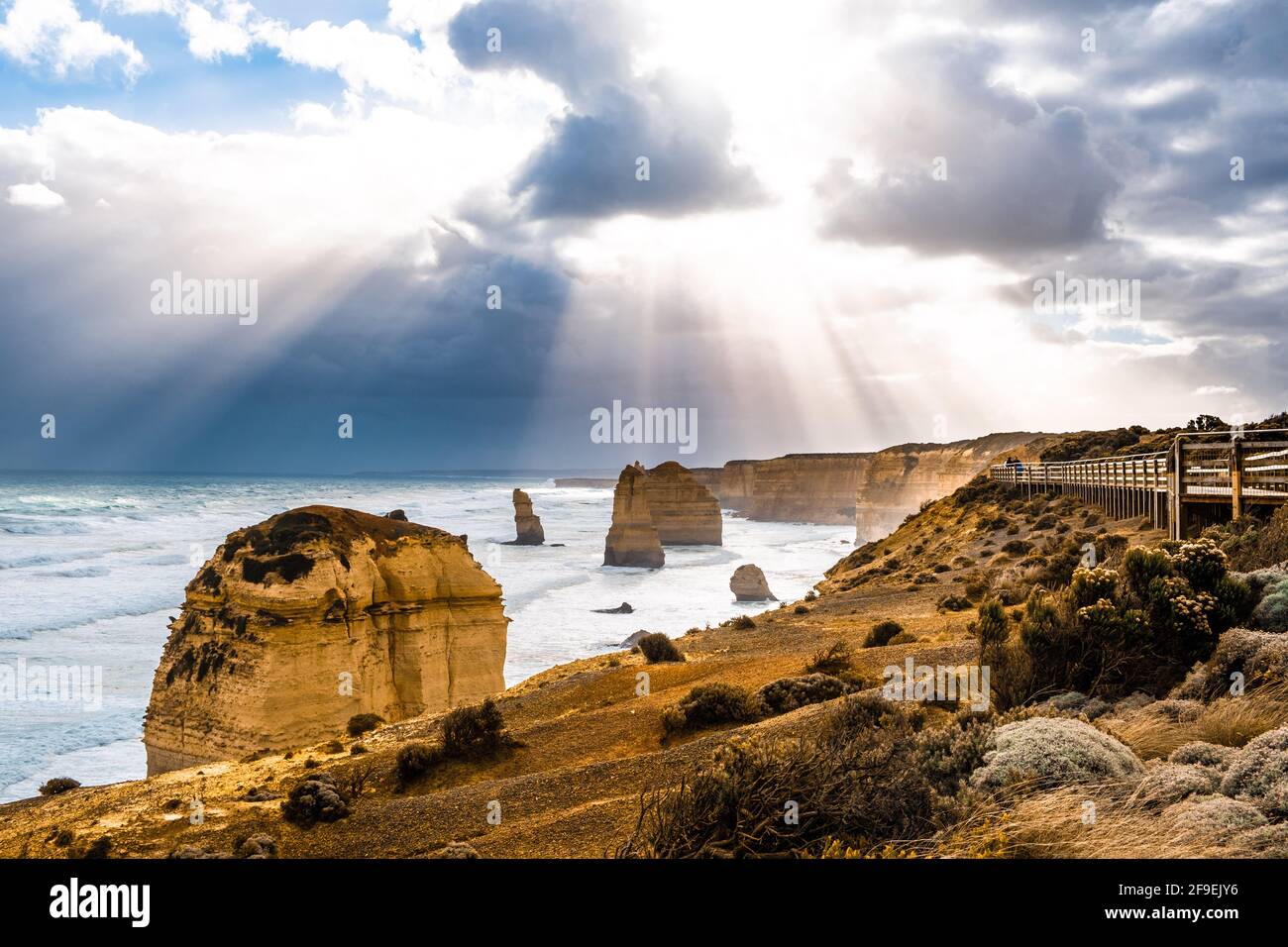 Le soleil traverse des nuages qui brillent sur les formations rocheuses des douze Apôtres sur Great Ocean Road, Victoria, Australie Banque D'Images