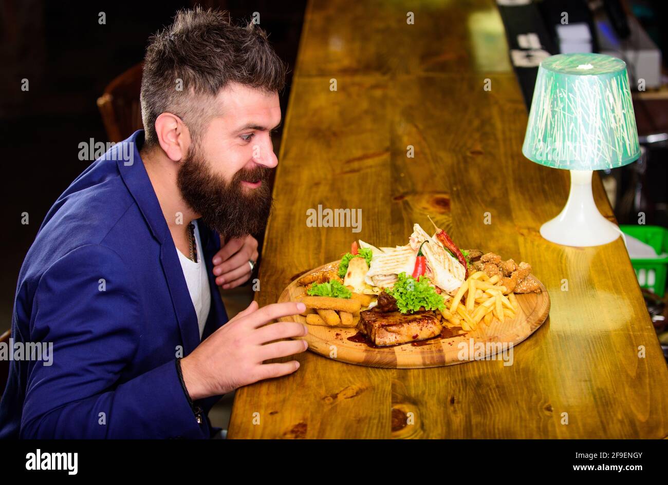 Costume d'homme d'affaires habillé assis au comptoir de bar. L'homme a reçu un repas avec des bâtonnets de pommes de terre frits, de la viande et du lavash. Bon repas. Il mérite un délicieux repas Banque D'Images