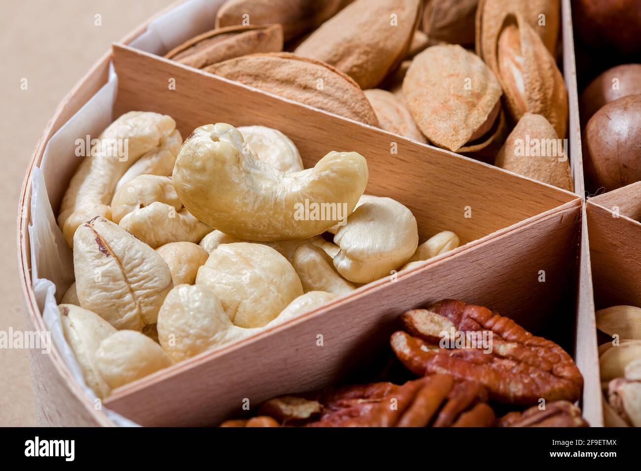 boîte en bois avec des cellules pour différents fruits à coque nourriture pour la nutrition saine de protéines gros plan noix de cajou, personne. Banque D'Images