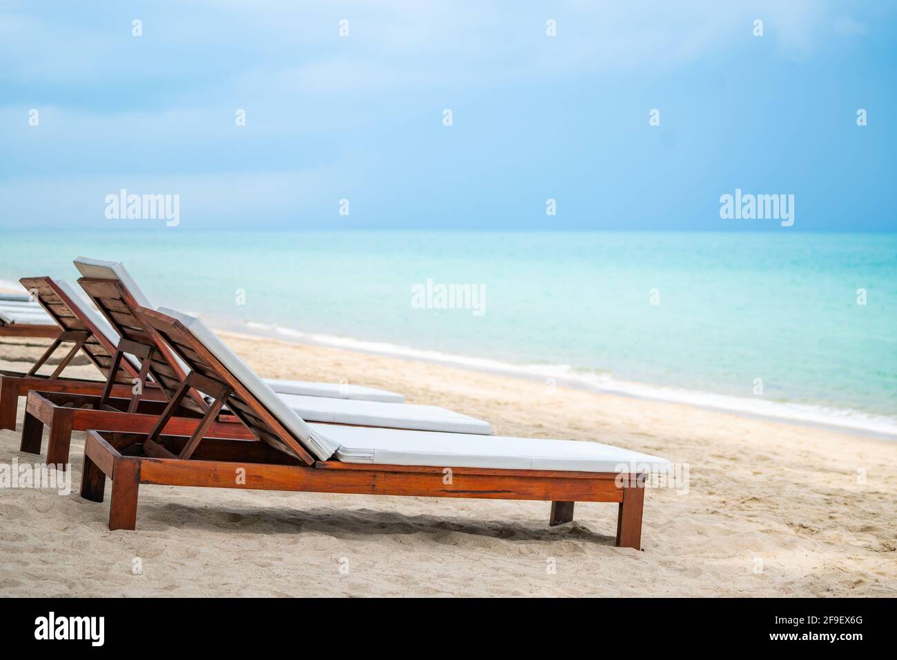 Plage de bois lit ou plage de bronzage avec coussin blanc sur la belle plage  avec l'océan turquoise et le ciel bleu, vue perspective avec espace pour la  copie, l'image Photo Stock -