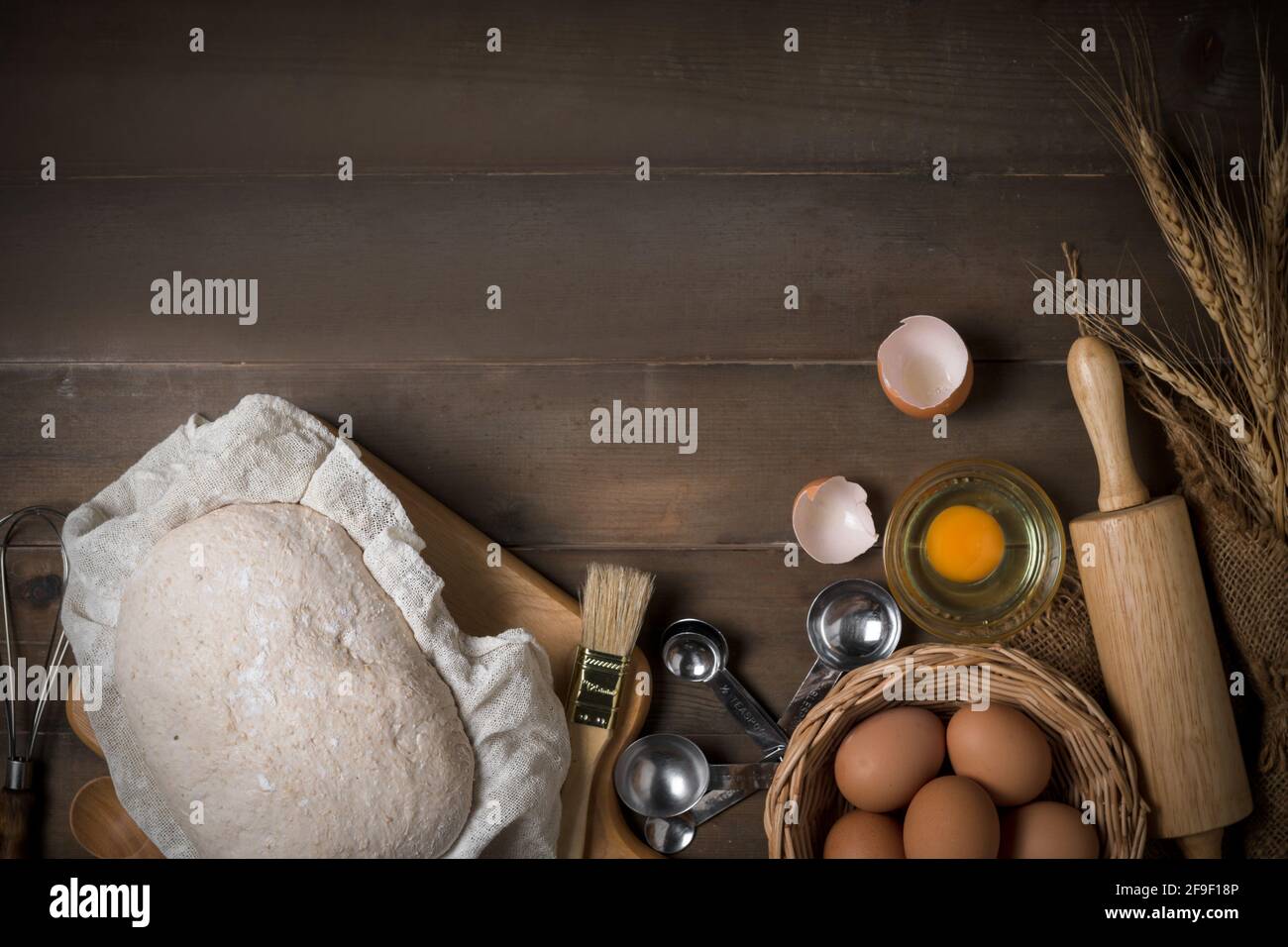 Ingrédient de pain de levain; pâte de blé et oeufs frais et équipement boulangerie pour faire du pain sur fond de bois, concept de boulangerie maison Banque D'Images