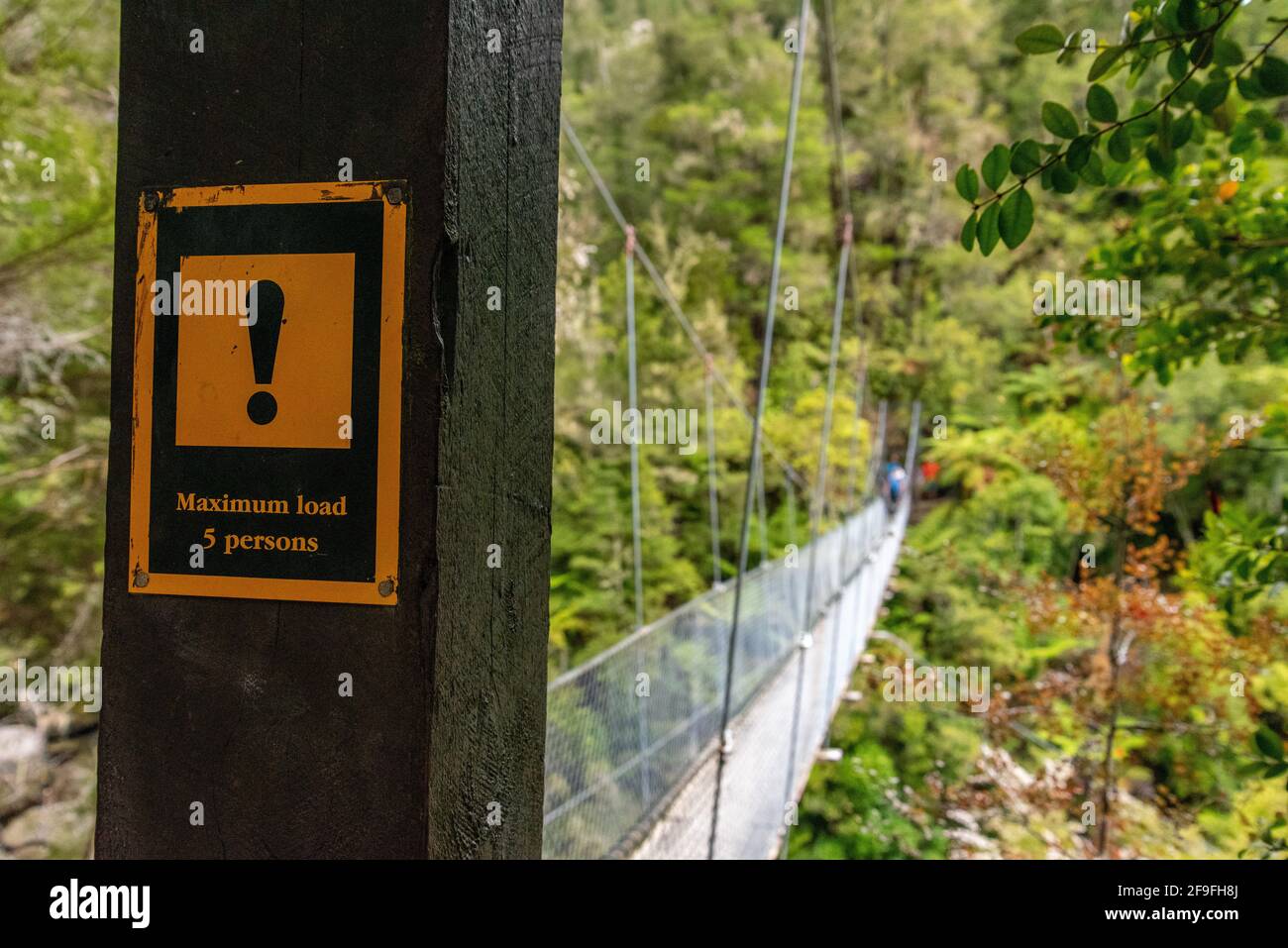 Panneaux d'avertissement sur une passerelle à suspension dans Abel Tasman Cost Track, Nouvelle-Zélande Banque D'Images