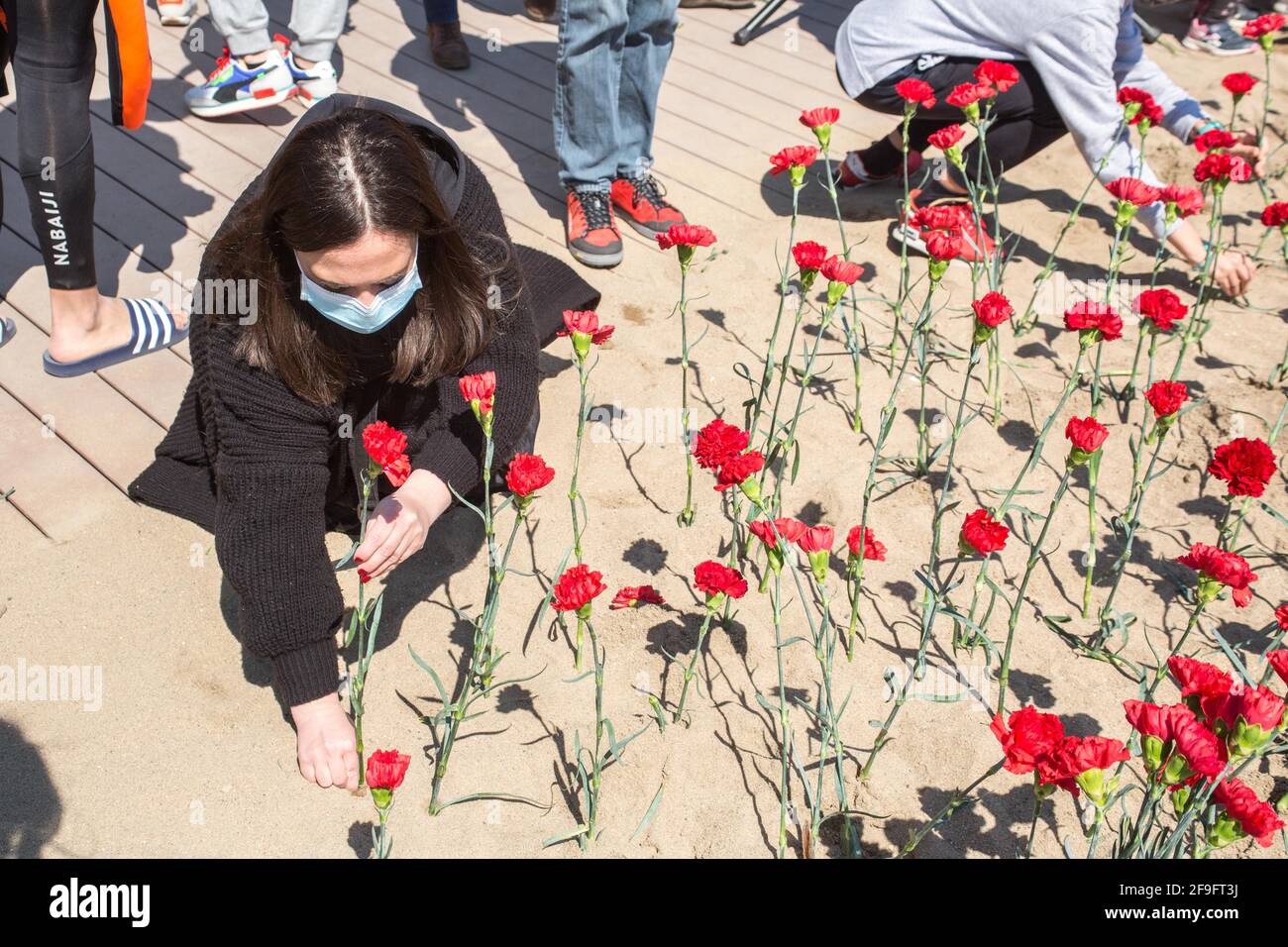 Une personne est vue planter un plantule d'une nation sur le sable de plage.Stop Mare Mortum, une plate-forme qui vise à promouvoir un changement dans les politiques européennes d'immigration et d'immigration afin d'assurer que les droits de l'homme sont garantis et respectés, a mené, sur la plage de Barceloneta à Barcelone, Une action visuelle pour dénoncer les morts constantes en Méditerranée et dans l'Atlantique. Quelque 150 personnes ont effectué une plantation d'une nation au nom des plus de 1200 personnes qui sont mortes en 2020 sur la route pour atteindre les îles Canaries. Banque D'Images